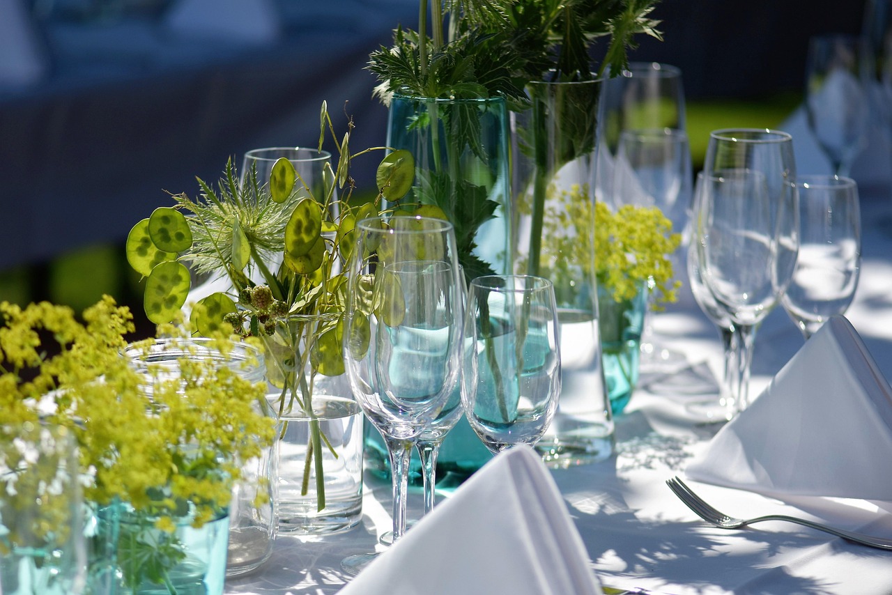 Festlich gedeckter Tisch mit Gläsern und Blumenschmuck für Hochzeitscatering