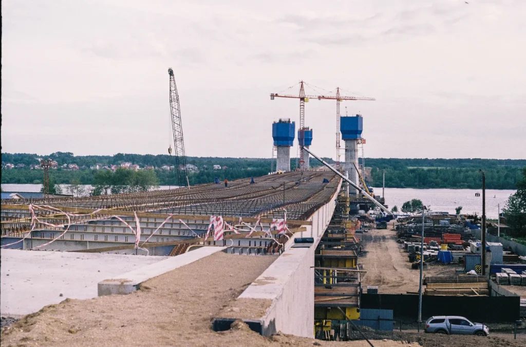 Brückenbaustelle mit Kränen über einem Fluss
